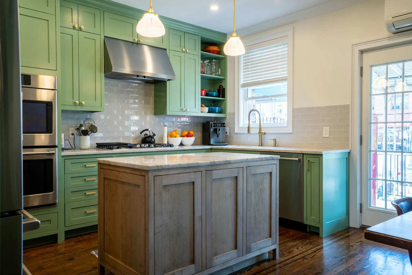 Kitchen design inspiration with green cabinets, a central island and natural wood flooring